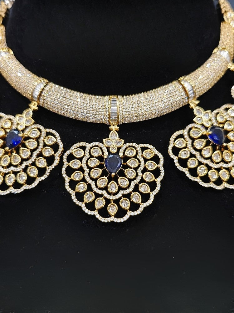 Close-up of an ornate Western American diamond Raizel Blue Necklace Set (Mehendi Polish) Collar jewellery set and earrings with Colored Stone and American Diamond. Reception-ready look featuring a statement American diamond jewelry set.
