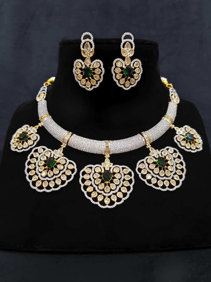 Close-up of an ornate Western American diamond Raizel Emerald Green Necklace Set (Dual Tone) Collar jewellery set and earrings with  Colored Stone and American Diamond. Bride-to-be styled in a premium American diamond artificial necklace for her reception party.