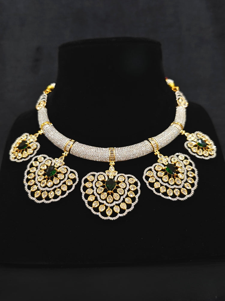 Close-up of an ornate Western American diamond Raizel Emerald Green Necklace Set (Dual Tone) Collar jewellery set and earrings with  Colored Stone and American Diamond. Bride-to-be styled in a premium American diamond artificial necklace for her reception party.