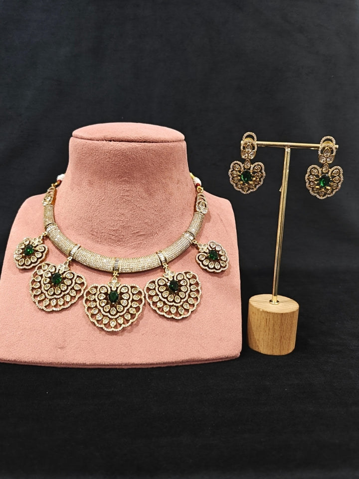 Close-up of an ornate Western American diamond Raizel Emerald Green Necklace Set (Mehendi Polish) Collar jewellery set and earrings with Colored Stone and American Diamond. Bride-to-be styled in a premium American diamond artificial necklace for her reception party.