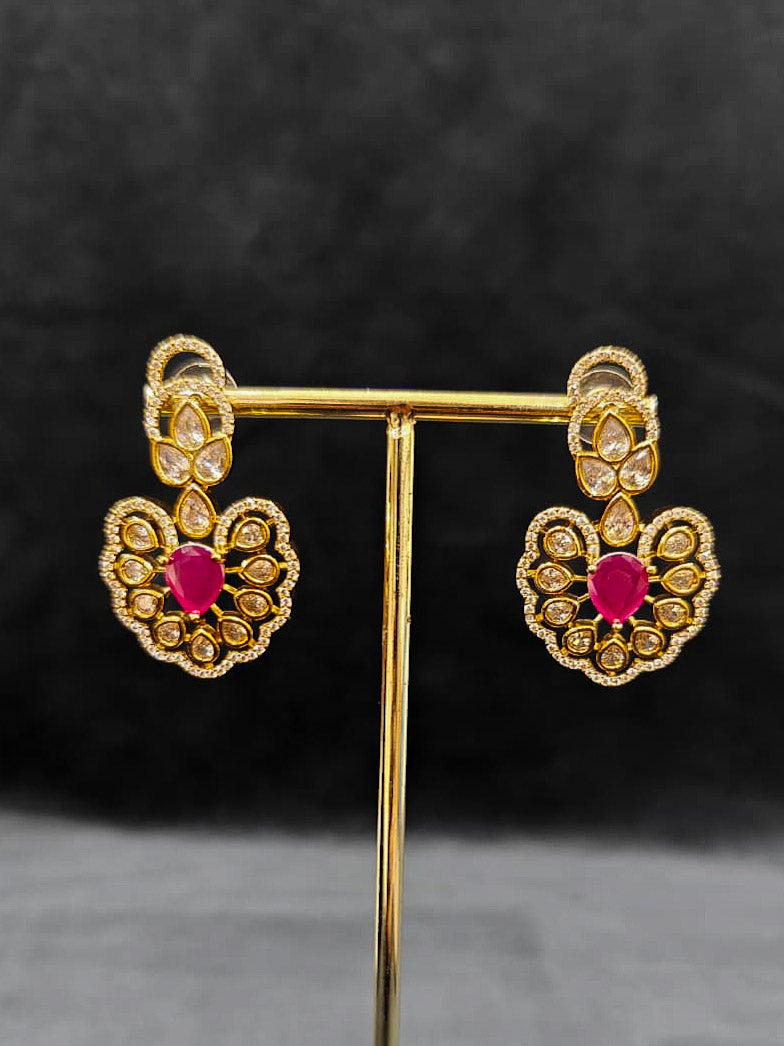 Close-up of an ornate Western American diamond Raizel Ruby Pink Necklace Set (Mehendi Polish) Collar jewellery set and earrings with Colored Stone and American Diamond. Woman styling a statement American diamond necklace with an off-shoulder gown for a reception.