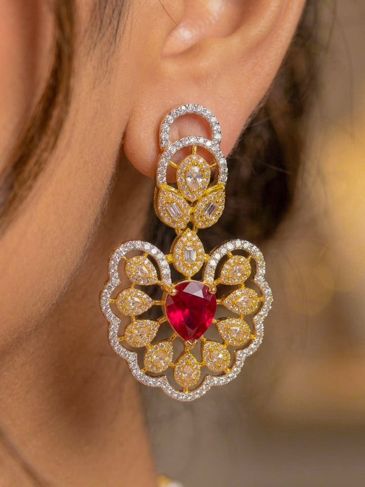 Close-up of a woman wearing an ornate Western American diamond Raizel Ruby Red Necklace Set (Dual Tone) Collar jewellery set and earrings with Ruby Red Colored Stone and American Diamond. Bride-to-be styled in a premium American diamond artificial necklace for her reception party.