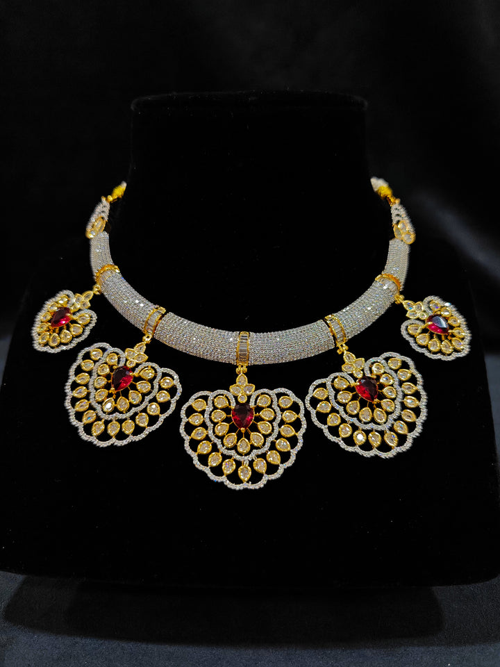 Close-up of an ornate Western American diamond Raizel Ruby Red Necklace Set (Dual Tone) Collar jewellery set and earrings with Ruby Red Colored Stone and American Diamond. Bride-to-be styled in a premium American diamond artificial necklace for her reception party.