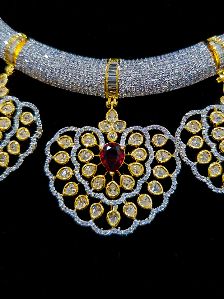 Close-up of an ornate Western American diamond Raizel Ruby Red Necklace Set (Dual Tone) Collar jewellery set and earrings with Ruby Red Colored Stone and American Diamond. Bride-to-be styled in a premium American diamond artificial necklace for her reception party.