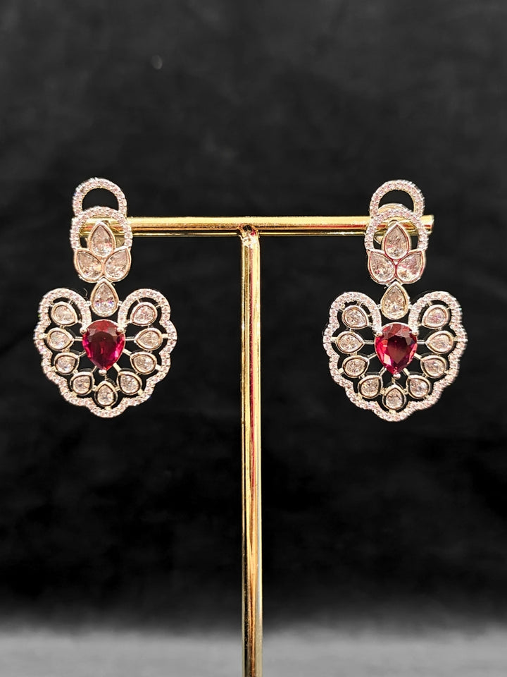 Close-up of an ornate Western American diamond Raizel Ruby Red Necklace Set (Silver Polish) Collar jewellery set and earrings with Colored Stone and American Diamond. Bride-to-be styled in a premium American diamond artificial necklace for her reception party.