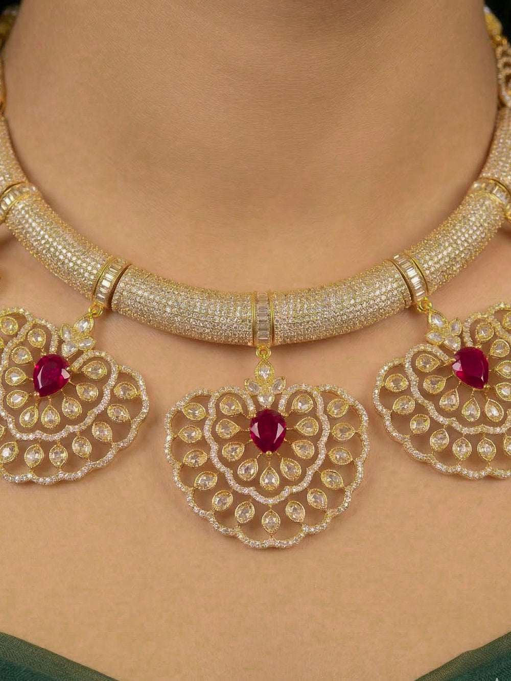 Close-up of a woman wearing an ornate Western American diamond Raizel Ruby red Necklace Set (Mehendi Polish) Collar jewellery set and earrings with Ruby Red Colored Stone and American Diamond. Bride-to-be styled in a premium American diamond artificial necklace for her reception party.