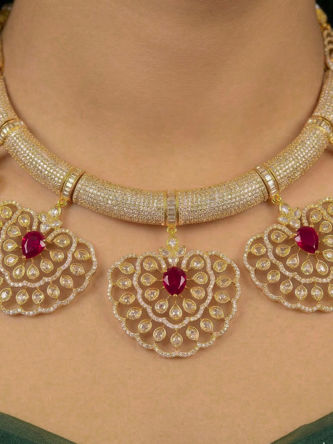 Close-up of a woman wearing an ornate Western American diamond Raizel Ruby red Necklace Set (Mehendi Polish) Collar jewellery set and earrings with Ruby Red Colored Stone and American Diamond. Bride-to-be styled in a premium American diamond artificial necklace for her reception party.