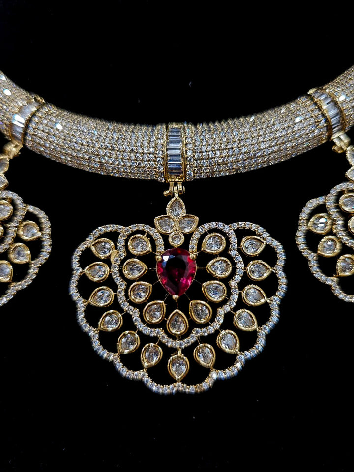 Close-up of an ornate Western American diamond Raizel Ruby red Necklace Set (Mehendi Polish) Collar jewellery set and earrings with Ruby Red Colored Stone and American Diamond. Bride-to-be styled in a premium American diamond artificial necklace for her reception party.