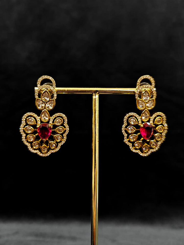 Close-up of an ornate Western American diamond Raizel Ruby red Necklace Set (Mehendi Polish) Collar jewellery set and earrings with Ruby Red Colored Stone and American Diamond. Bride-to-be styled in a premium American diamond artificial necklace for her reception party.