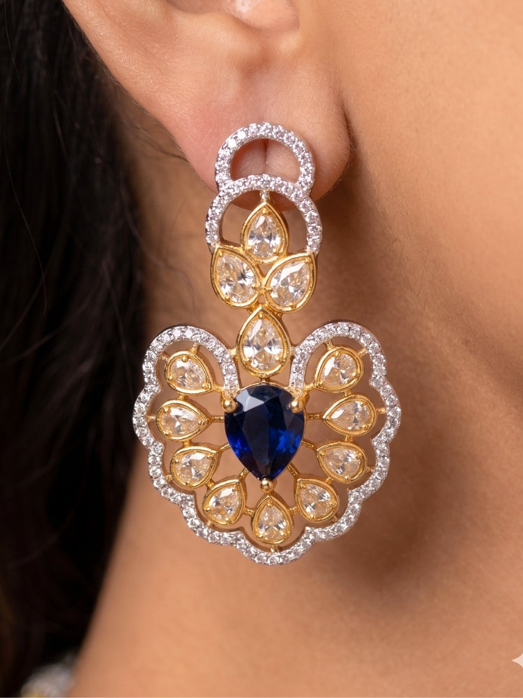 Close-up of a woman wearing an ornate Western American diamond Raizel Blue Necklace Set (Dual Tone) Collar jewellery set and earrings with Colored Stone and American Diamond. Bride-to-be styled in a premium American diamond artificial necklace for her reception party.