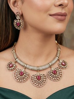 Close-up of a woman wearing an ornate Western American diamond Raizel Ruby Pink Necklace Set (Mehendi Polish) Collar jewellery set and earrings with Colored Stone and American Diamond. Woman styling a statement American diamond necklace with an off-shoulder gown for a reception.