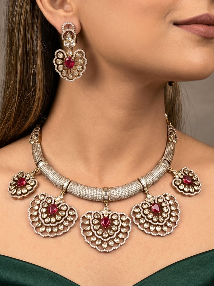 Close-up of a woman wearing an ornate Western American diamond Raizel Ruby red Necklace Set (Mehendi Polish) Collar jewellery set and earrings with Ruby Red Colored Stone and American Diamond. Bride-to-be styled in a premium American diamond artificial necklace for her reception party.