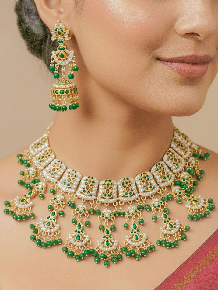 Close-up of a woman wearing an ornate traditional jadau gold jewellery set and jadau earrings with Beads and gemstones. Woman pairing a traditional Jadau necklace with a silk saree.Woman wearing a royal Jadau necklace for festive events in India.