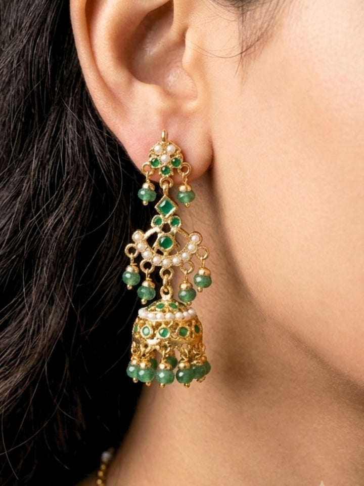 Close-up of a woman wearing an ornate traditional jadau gold jewellery set and jadau earrings with Beads and gemstones. Woman pairing a traditional Jadau necklace with a silk saree.Woman wearing a royal Jadau necklace for festive events in India.