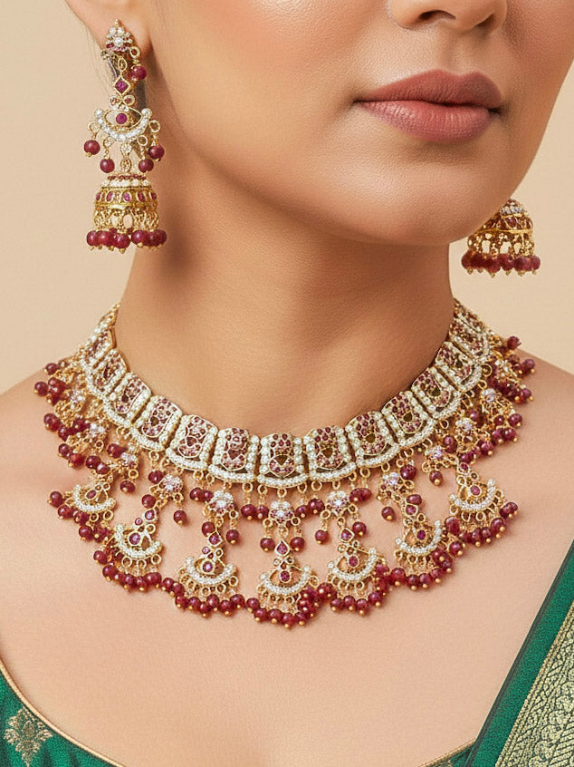 Close-up of a woman wearing an ornate traditional Ruby Pink jadau gold jewellery set and jadau earrings with Beads and gemstones. Close-up of a luxury Jadau imitation necklace styled with a bridal lehenga.Bride wearing a luxury Jadau necklace for her reception ceremony.
