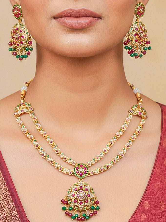 Close-up of a woman wearing an ornate traditional Collar jadau gold jewellery set and jadau earrings with Beads and Pink & Green Colored Stones. Woman wearing a royal Jadau necklace for festive events in India. Festive celebration look featuring a Jadau artificial necklace.