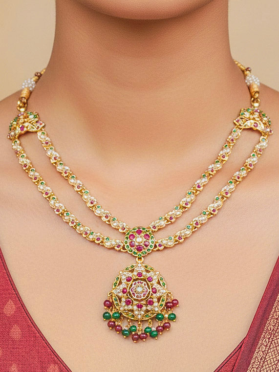 Close-up of a woman wearing an ornate traditional Collar jadau gold jewellery set and jadau earrings with Beads and Pink & Green Colored Stones. Woman wearing a royal Jadau necklace for festive events in India. Festive celebration look featuring a Jadau artificial necklace.