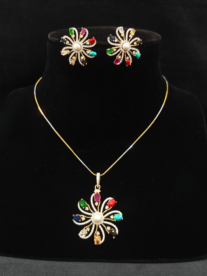 Close-up of an ornate Indo-Western Multi-Color (gold Polish) Pendant set and earrings with American Diamond and Colored Stones. Mehendi function outfit styled with a lightweight American Diamond Pendant. Close-up of high-quality artificial American Diamond Pendant craftsmanship.