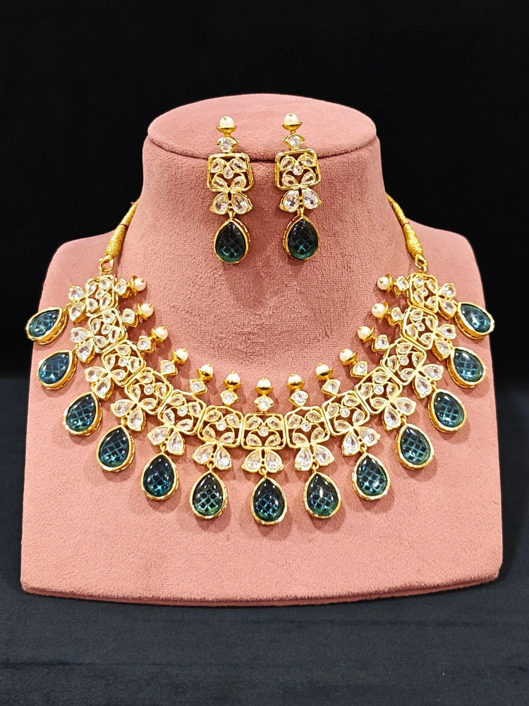 Close-up of an ornate traditional (Gold Polish) Blue Collar jewellery set and earrings with Diamond Polki, Monalisa Stone and Colored Stones. Wedding guest wearing a sparkling American diamond necklace with a saree. A graceful woman wearing a trending American diamond necklace for a 2026 wedding celebration.