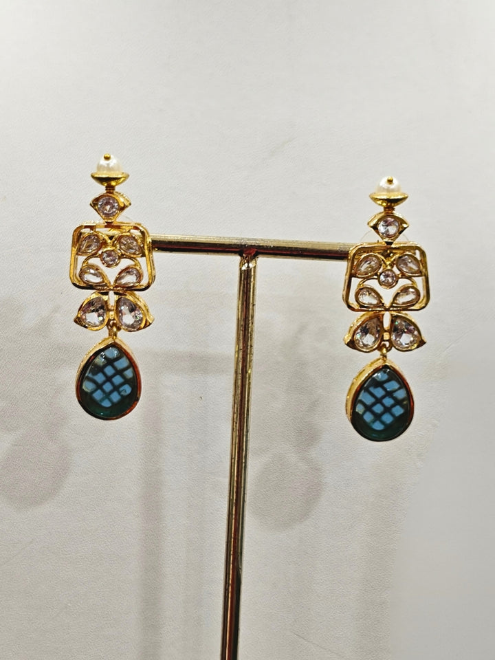 Close-up of an ornate traditional (Gold Polish) Blue Collar jewellery set and earrings with Diamond Polki, Monalisa Stone and Colored Stones. Wedding guest wearing a sparkling American diamond necklace with a saree. A graceful woman wearing a trending American diamond necklace for a 2026 wedding celebration.