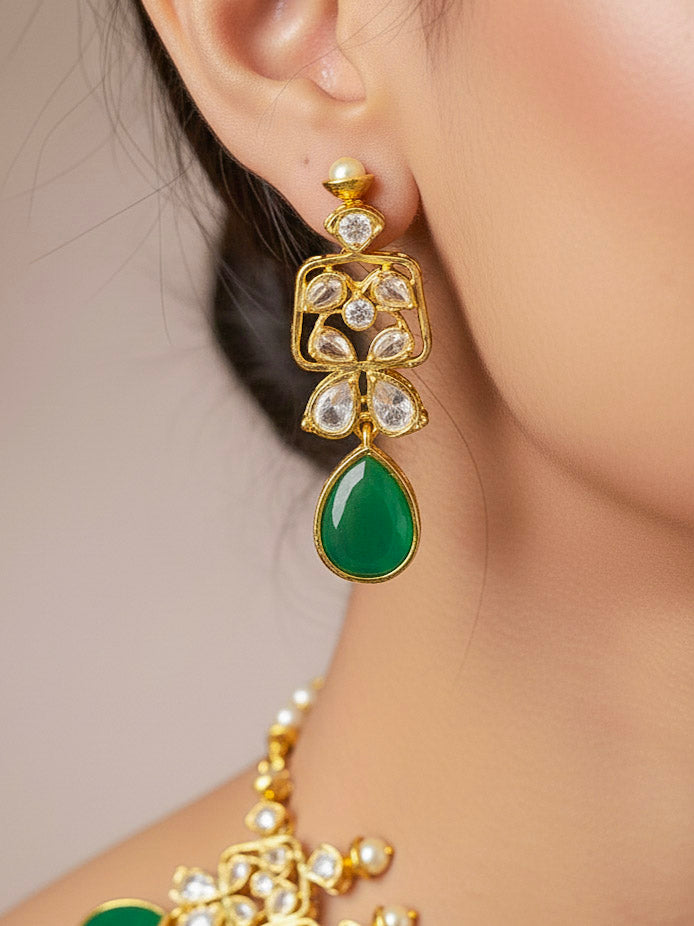 Close-up of a woman wearing an ornate traditional (Gold Polish) Dark Green Collar jewellery set and earrings with Diamond Polki, Monalisa Stone and Colored Stones. Wedding guest wearing a sparkling American diamond necklace with a saree. A graceful woman wearing a trending American diamond necklace for a 2026 wedding celebration.