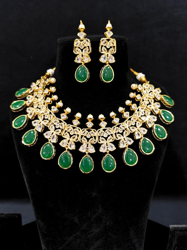 Close-up of an ornate traditional (Gold Polish) Dark Green Collar jewellery set and earrings with Diamond Polki, Monalisa Stone and Colored Stones. Wedding guest wearing a sparkling American diamond necklace with a saree. A graceful woman wearing a trending American diamond necklace for a 2026 wedding celebration.