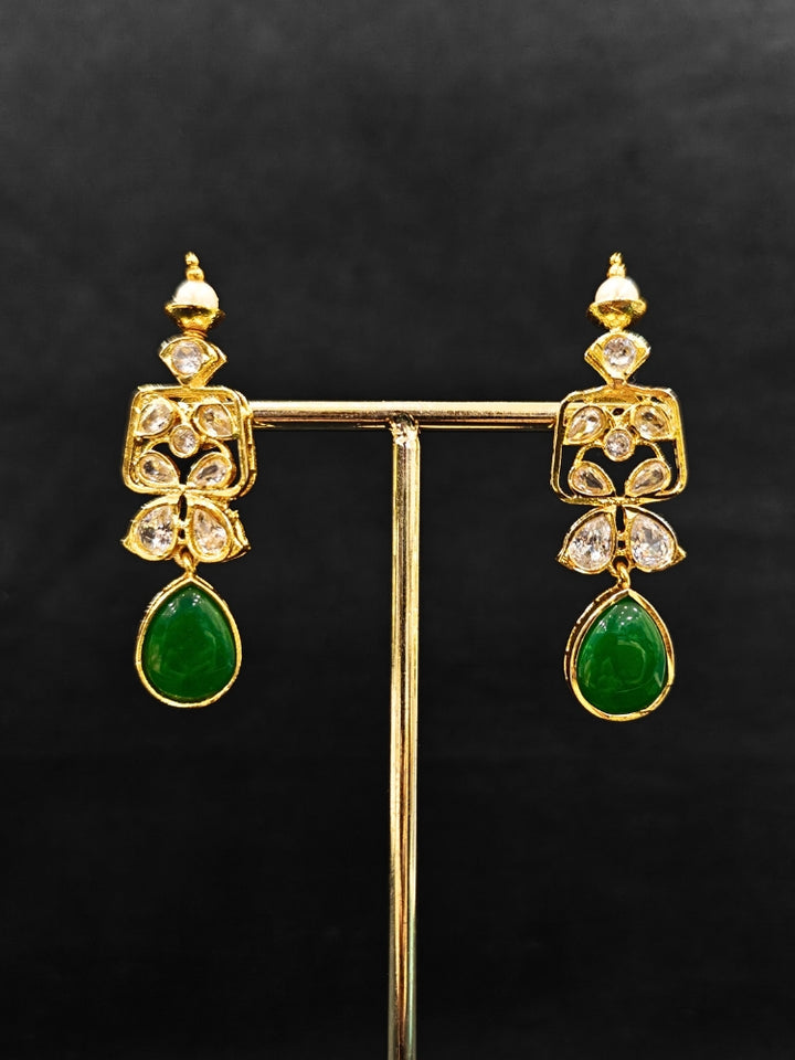 Close-up of an ornate traditional (Gold Polish) Dark Green Collar jewellery set and earrings with Diamond Polki, Monalisa Stone and Colored Stones. Wedding guest wearing a sparkling American diamond necklace with a saree. A graceful woman wearing a trending American diamond necklace for a 2026 wedding celebration.