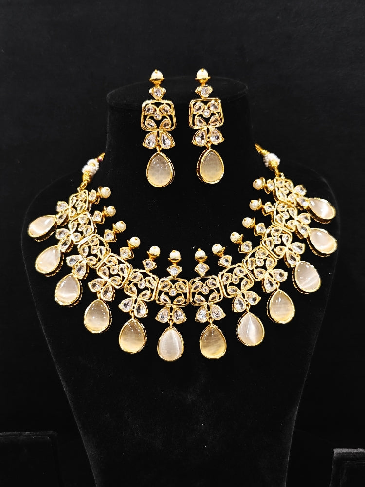 Close-up of an ornate traditional (Gold Polish) Grey Collar jewellery set and earrings with Diamond Polki, Monalisa Stone and Colored Stones. Wedding guest wearing a sparkling American diamond necklace with a saree. A graceful woman wearing a trending American diamond necklace for a 2026 wedding celebration.
