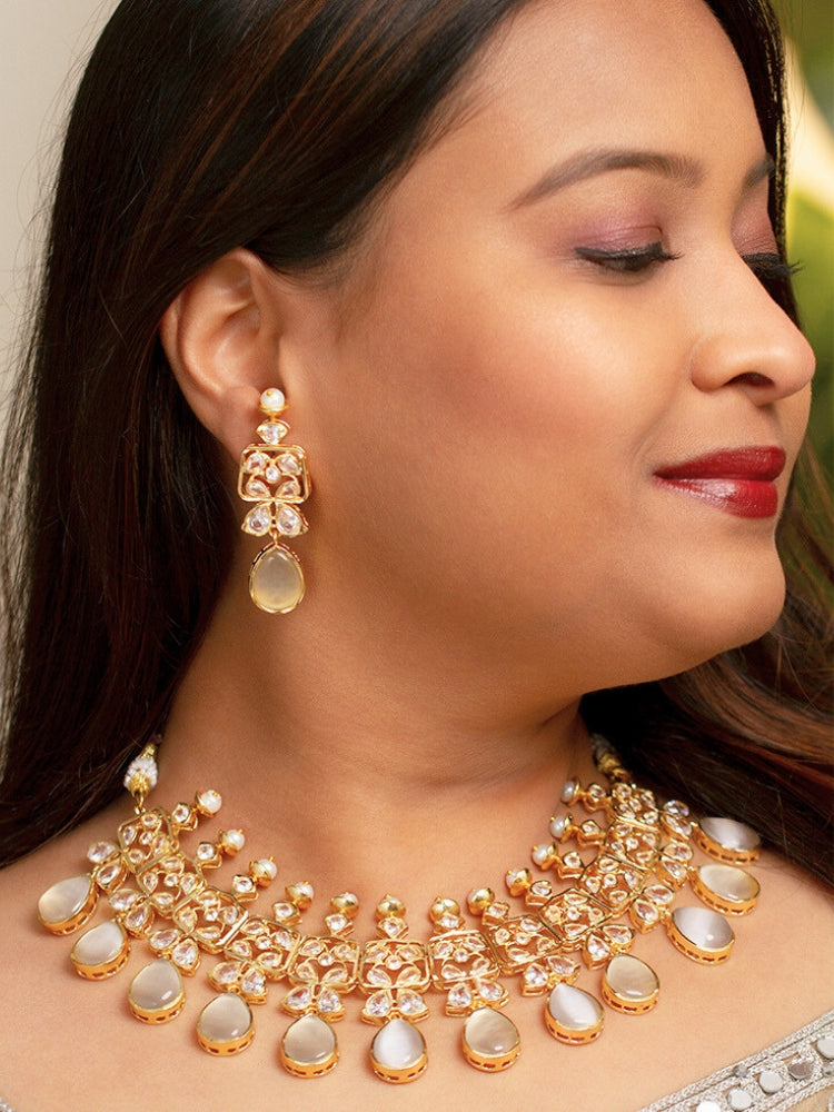 Close-up of a woman wearing an ornate traditional (Gold Polish) Grey Collar jewellery set and earrings with Diamond Polki, Monalisa Stone and Colored Stones. Wedding guest wearing a sparkling American diamond necklace with a saree. A graceful woman wearing a trending American diamond necklace for a 2026 wedding celebration.