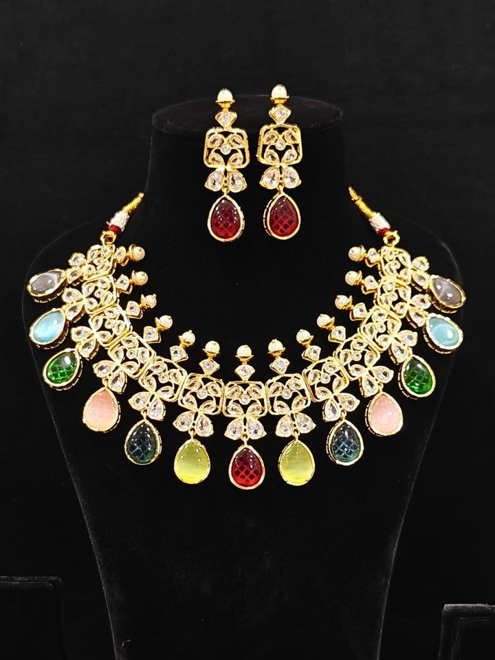 Close-up of an ornate traditional (Gold Polish) Multi-Color Collar jewellery set and earrings with Diamond Polki, Monalisa Stone and Colored Stones. Wedding guest wearing a sparkling American diamond necklace with a saree. A graceful woman wearing a trending American diamond necklace for a 2026 wedding celebration.