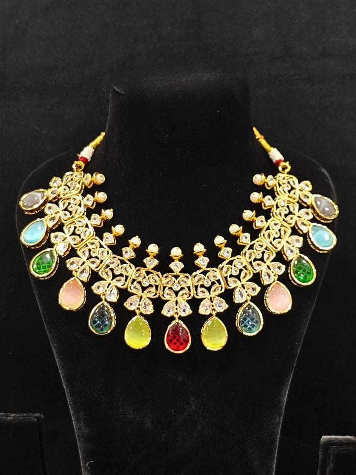 Close-up of an ornate traditional (Gold Polish) Multi-Color Collar jewellery set and earrings with Diamond Polki, Monalisa Stone and Colored Stones. Wedding guest wearing a sparkling American diamond necklace with a saree. A graceful woman wearing a trending American diamond necklace for a 2026 wedding celebration.