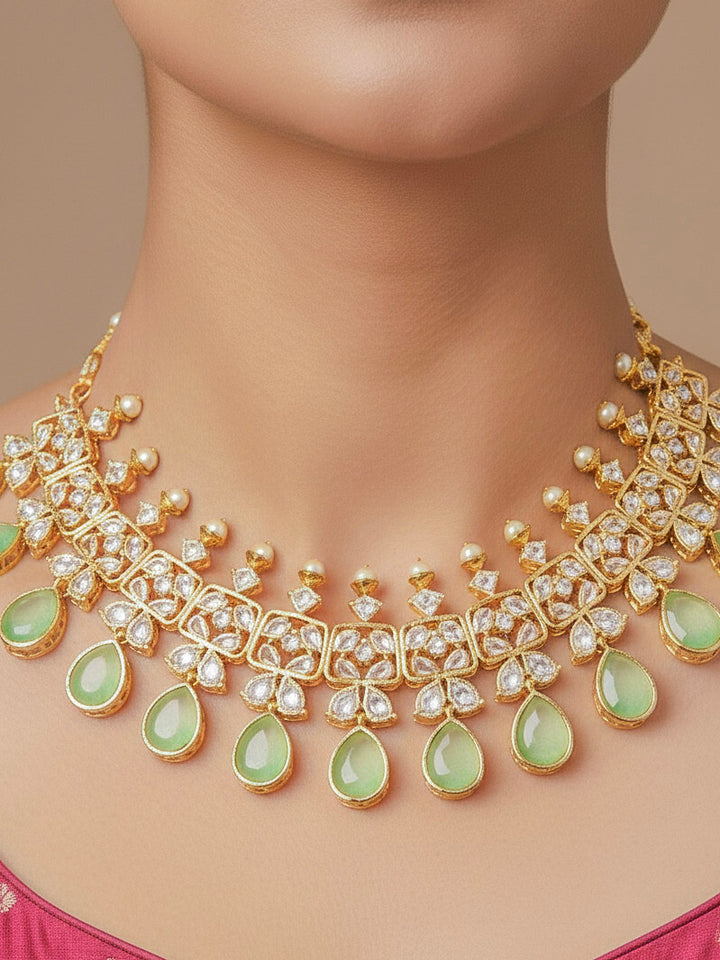 Close-up of a woman wearing an ornate traditional (Gold Polish) Parrot Green Collar jewellery set and earrings with Diamond Polki, Monalisa Stone and Colored Stones. Wedding guest wearing a sparkling American diamond necklace with a saree. A graceful woman wearing a trending American diamond necklace for a 2026 wedding celebration.