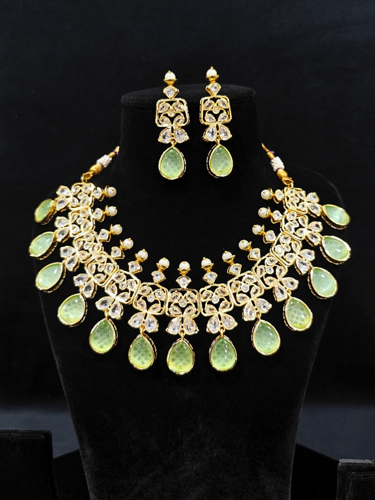 Close-up of an ornate traditional (Gold Polish) Parrot Green Collar jewellery set and earrings with Diamond Polki, Monalisa Stone and Colored Stones. Wedding guest wearing a sparkling American diamond necklace with a saree. A graceful woman wearing a trending American diamond necklace for a 2026 wedding celebration.