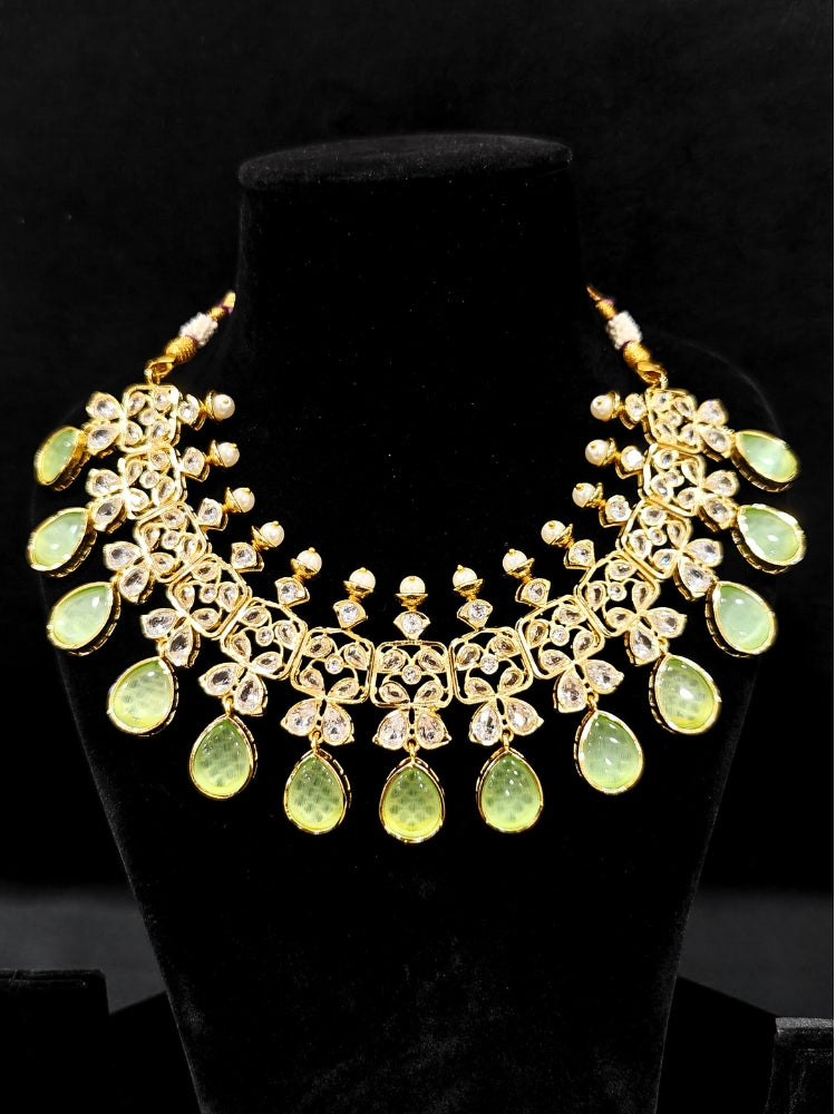 Close-up of an ornate traditional (Gold Polish) Parrot Green Collar jewellery set and earrings with Diamond Polki, Monalisa Stone and Colored Stones. Wedding guest wearing a sparkling American diamond necklace with a saree. A graceful woman wearing a trending American diamond necklace for a 2026 wedding celebration.