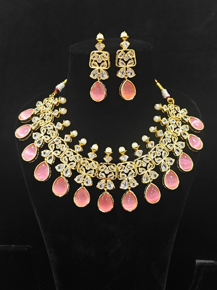 Close-up of an ornate traditional (Gold Polish) Pink Collar jewellery set and earrings with Diamond Polki, Monalisa Stone and Colored Stones. Wedding guest wearing a sparkling American diamond necklace with a saree. A graceful woman wearing a trending American diamond necklace for a 2026 wedding celebration.