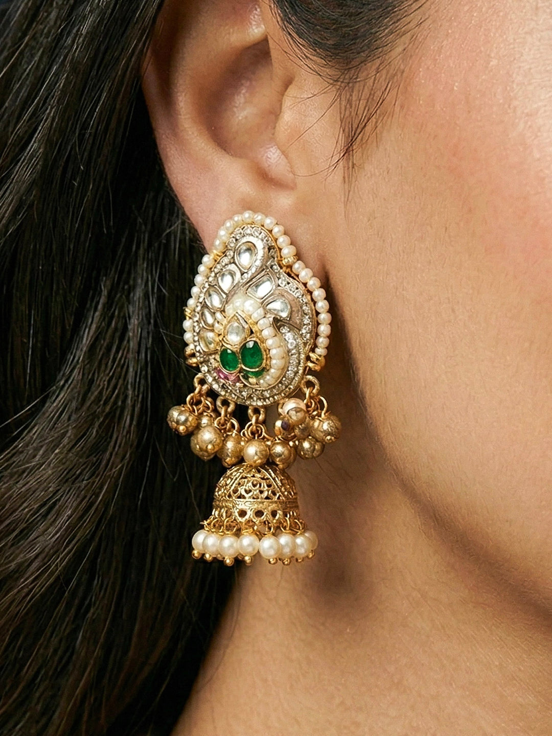 Close-up of a woman wearing an ornate traditional KASHMIRI-BOHO Meenakari Green and Ruby Pink gold Collar jewellery set and earrings with Pachi Kundan, Silver Balls, Pearls, Doublet Stones, Tumble Stone, Ghungroo and Meenakari. Festive celebration look enhanced with traditional Meenakari jewelry. 