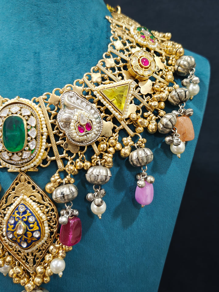 Close-up of an ornate traditional KASHMIRI-BOHO Meenakari Green & Yellow gold Collar jewellery set and earrings with Pachi Kundan, Silver Balls, Pearls, Doublet Stones, Tumble Stone, Ghungroo and Meenakari. Festive celebration look enhanced with traditional Meenakari jewelry. 