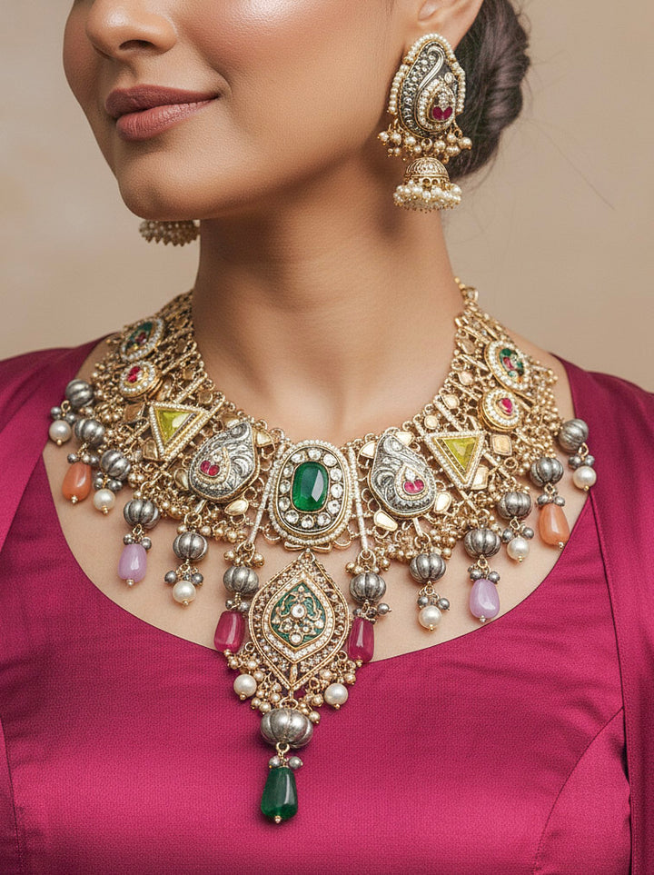 Close-up of a woman wearing an ornate traditional KASHMIRI-BOHO Meenakari Green & Yellow gold Collar jewellery set and earrings with Pachi Kundan, Silver Balls, Pearls, Doublet Stones, Tumble Stone, Ghungroo and Meenakari. Festive celebration look enhanced with traditional Meenakari jewelry. 