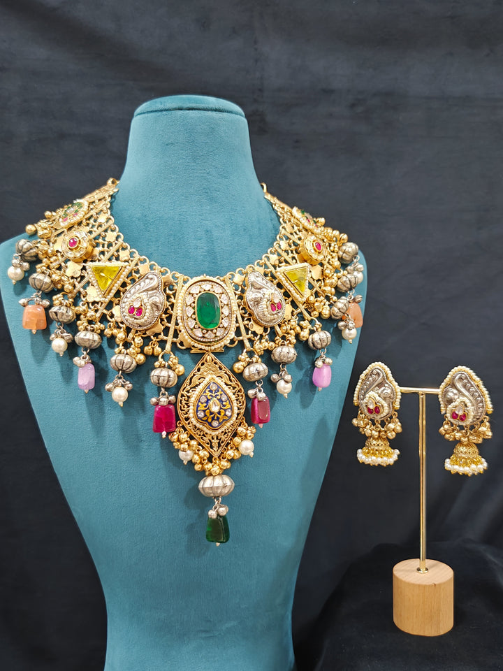 Close-up of an ornate traditional KASHMIRI-BOHO Meenakari Green & Yellow gold Collar jewellery set and earrings with Pachi Kundan, Silver Balls, Pearls, Doublet Stones, Tumble Stone, Ghungroo and Meenakari. Festive celebration look enhanced with traditional Meenakari jewelry. 