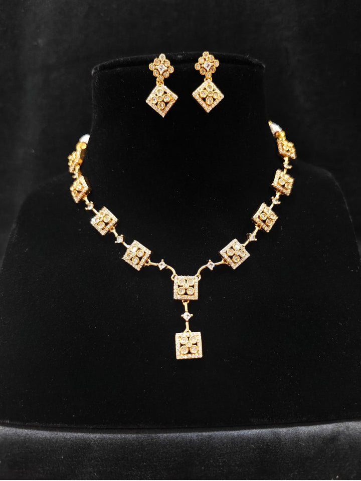 Close-up of an ornate Indo-western (gold Polish) Collar Diamond jewellery set and earrings with American Diamond. Festive Diwali outfit styled with an American diamond artificial necklace. Indo-western outfit styled with a statement American diamond necklace set.