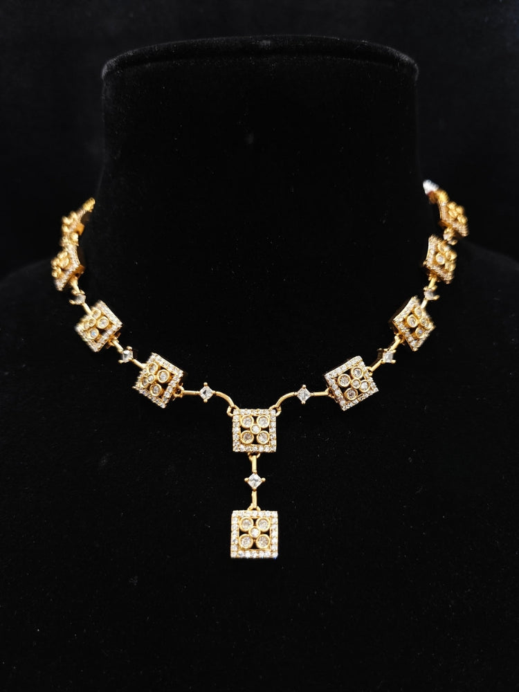 Close-up of an ornate Indo-western (gold Polish) Collar Diamond jewellery set and earrings with American Diamond. Festive Diwali outfit styled with an American diamond artificial necklace. Indo-western outfit styled with a statement American diamond necklace set.