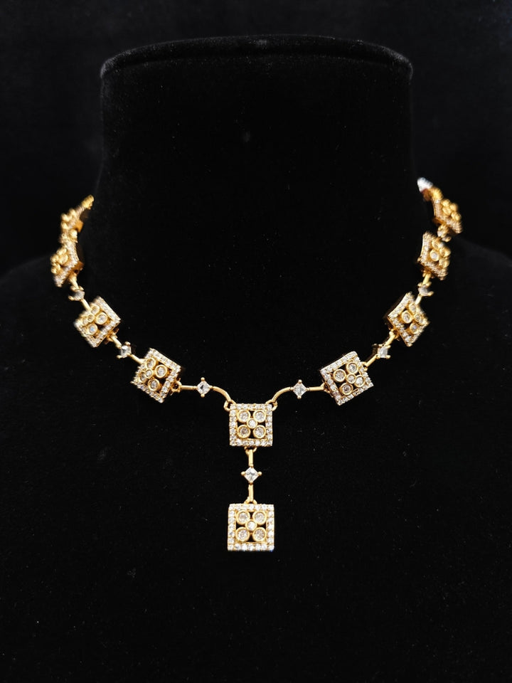Close-up of an ornate Indo-western (gold Polish) Collar Diamond jewellery set and earrings with American Diamond. Festive Diwali outfit styled with an American diamond artificial necklace. Indo-western outfit styled with a statement American diamond necklace set.