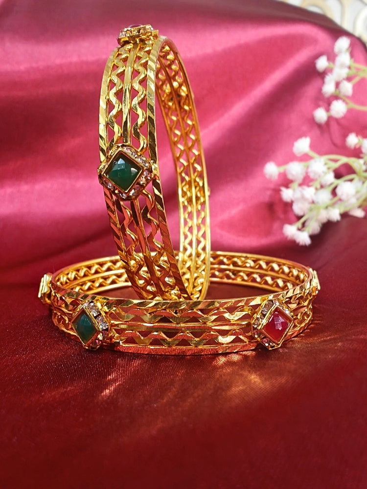 Close-up of an ornate traditional (Gold Polish) Bangles Set with American Diamond and Pink & Green Colored Stones. Woman stacking artificial Colored Stone bangles for a festive Diwali celebration. Festive Navratri outfit paired with stacked imitation Colored Stone bangles.