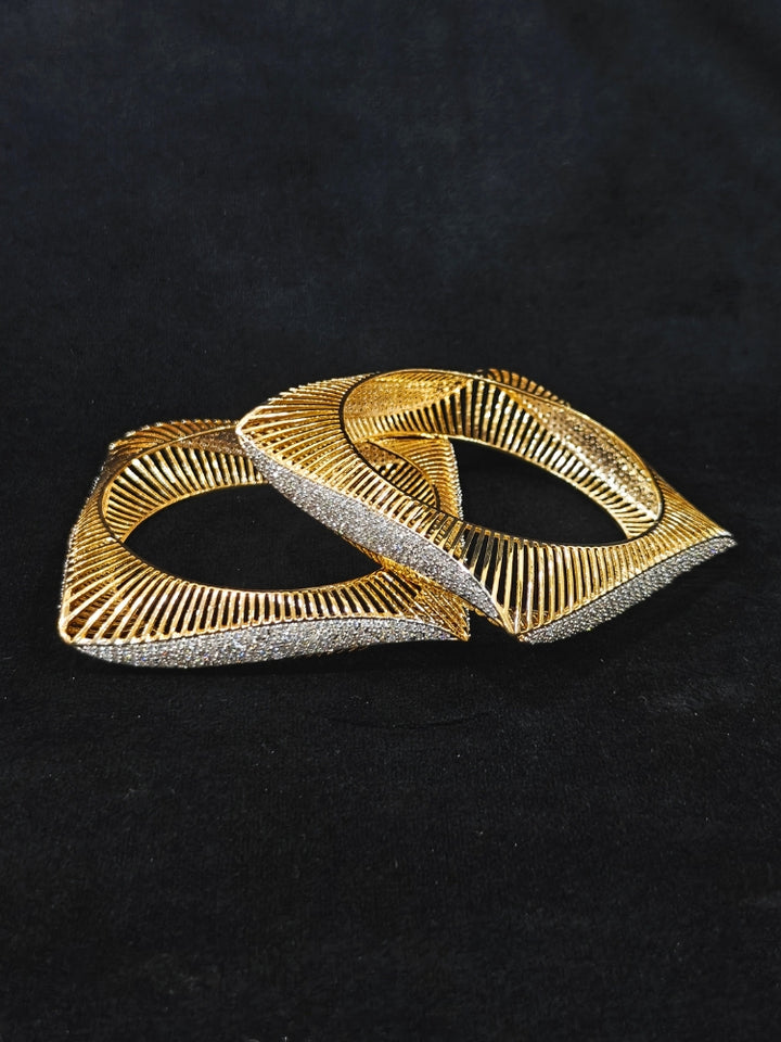 Close-up of an ornate Indo-western Diamond gold Bangles with American Diamond and Filigree work. Stacking artificial American Diamond bangles for a festive Diwali celebration. Close-up of sparkling artificial American Diamond bangles for party wear.