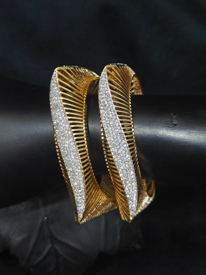Close-up of an ornate Indo-western Diamond gold Bangles with American Diamond and Filigree work. Stacking artificial American Diamond bangles for a festive Diwali celebration. Close-up of sparkling artificial American Diamond bangles for party wear.