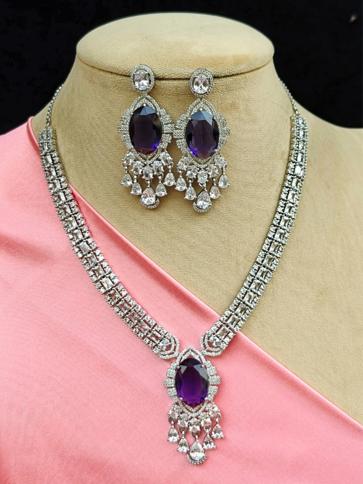 Close-up of a luxurious artificial diamond jewelry featuring a designer diamond necklace with purple colored stone and earrings set, crafted for bridal fashion and high-end weddings. This beautiful diamond jewelry set offers the brilliance of real diamonds at an affordable price.