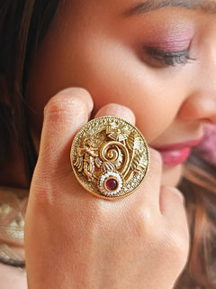 A woman wearing the Red Akshara Ring featuring a traditional gold Ring with Goddess Krishna, along with Red color stone & Pearls. Woman wearing temple artificial Ring for a cultural event in India.