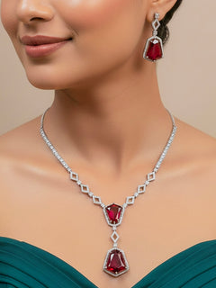 Close-up of a woman wearing an ornate Western Red (Silver Polish) Diamond jewellery set and earrings with American Diamond and Colored Stones. Festive Diwali outfit styled with an American diamond artificial necklace. Close-up of a party look featuring a premium American diamond necklace.