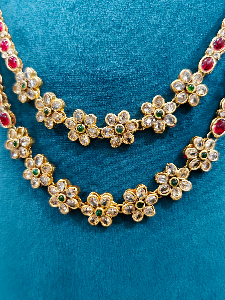 The Red & Green Karuna Temple Necklace Set featuring a traditional gold Long necklace and matching earrings with Red and green colored stones, Close-up of detailed temple carvings in artificial wedding jewelry.