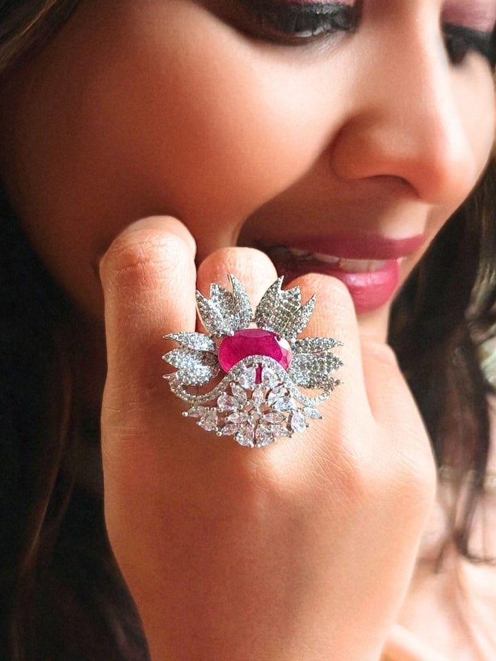 Close-up of a woman wearing an ornate Western (Silver Polish) Red Ring with American Diamond and Red Colored Stones. Party wear outfit completed with a lightweight American diamond Ring. Elegant wedding jewelry look featuring a premium artificial American diamond Ring.